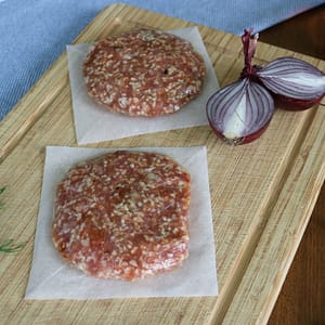 Twee lamsburgers op een houten plank.